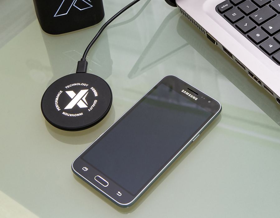 Wireless QI charger pad next to a mobile phone